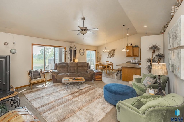 living room featuring lofted ceiling and ceiling fan with notable chandelier