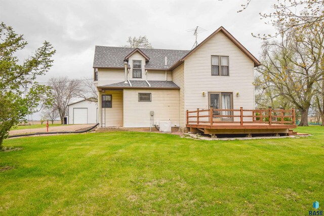 back of house with a yard, a wooden deck, and a garage