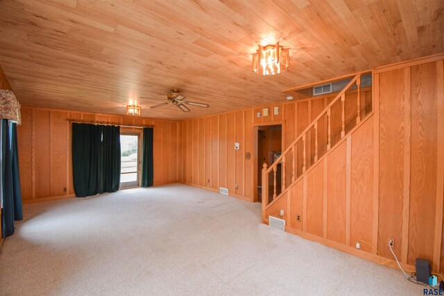 spare room featuring wood ceiling, wood walls, ceiling fan, and carpet flooring