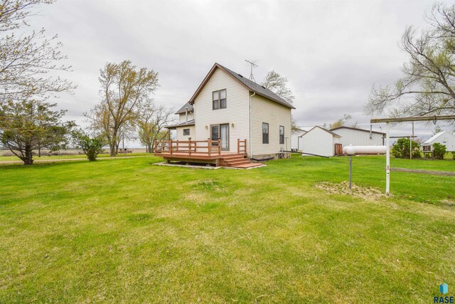 rear view of property with a wooden deck and a yard