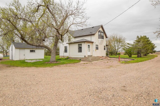 view of front of property featuring an outdoor structure and a front yard