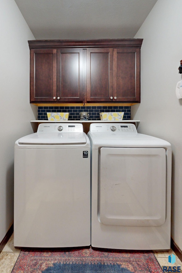 washroom with cabinets and washing machine and dryer