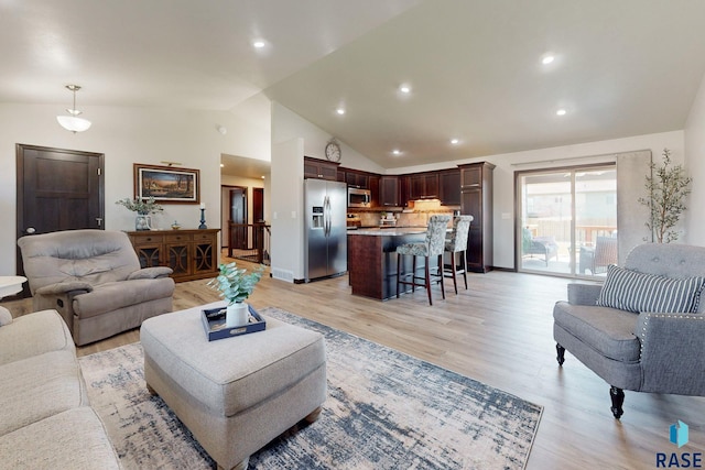 living room featuring light wood-type flooring and high vaulted ceiling