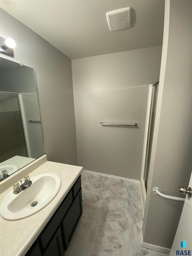 bathroom with an enclosed shower and vanity