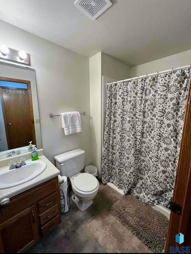 bathroom with toilet, vanity, and a textured ceiling