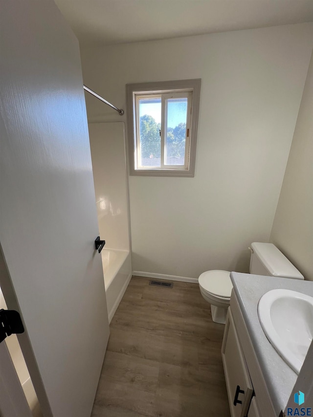 full bathroom with  shower combination, wood-type flooring, vanity, and toilet