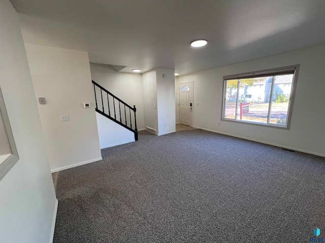 spare room featuring dark colored carpet