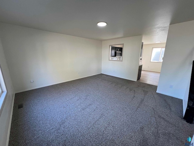 empty room featuring dark colored carpet