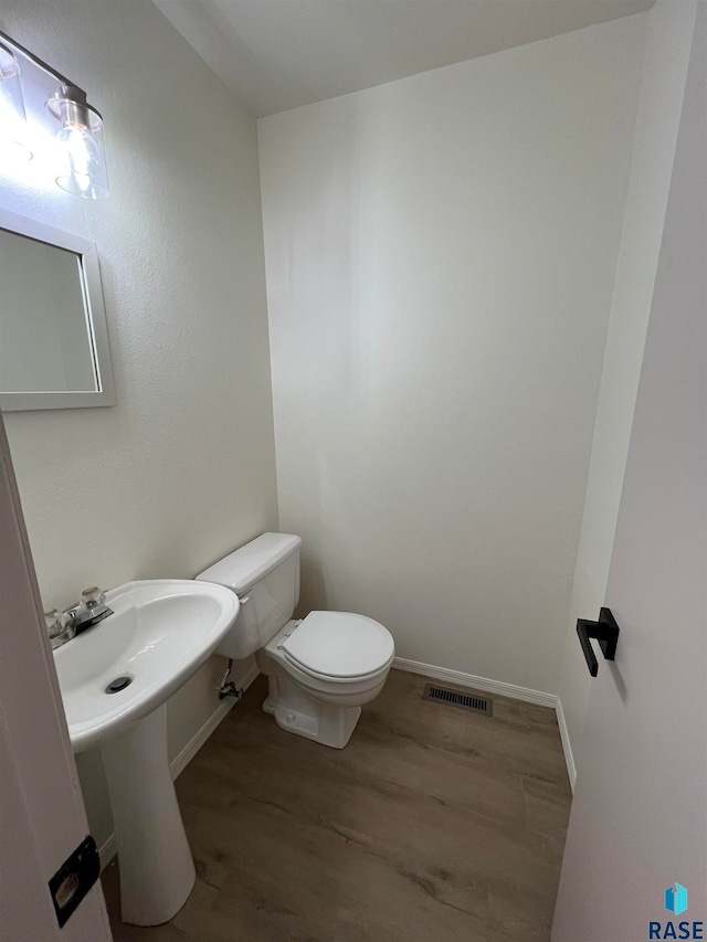 bathroom featuring hardwood / wood-style flooring and toilet