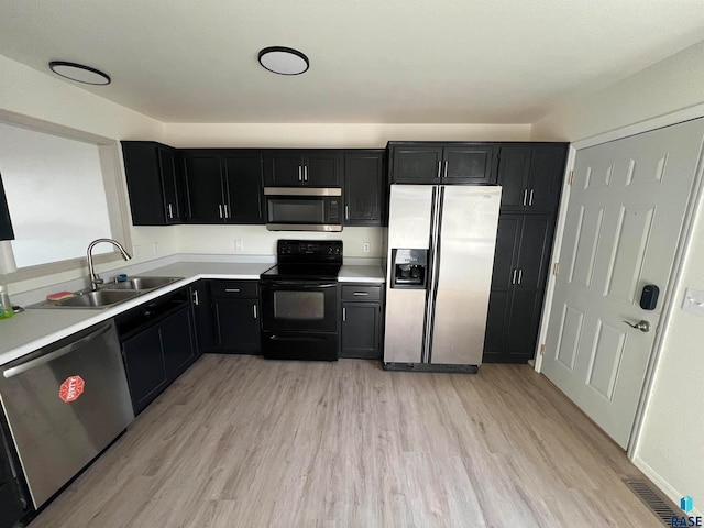 kitchen featuring appliances with stainless steel finishes, light hardwood / wood-style floors, and sink