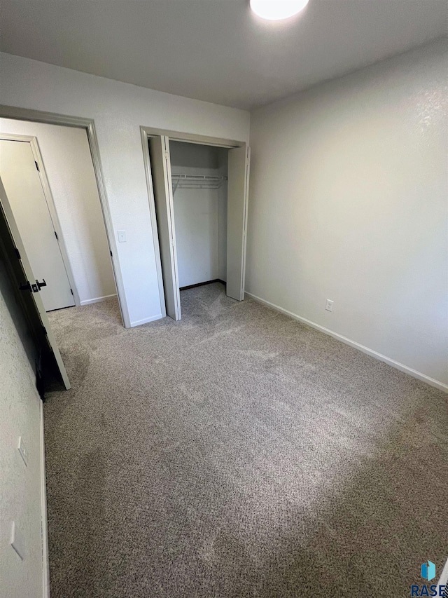 unfurnished bedroom featuring carpet and a closet