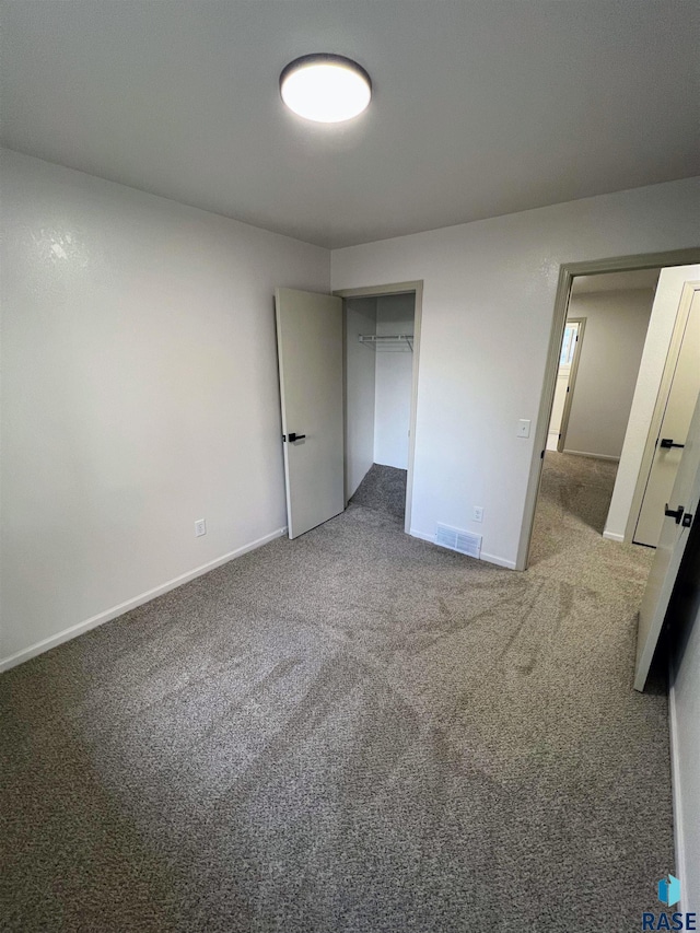 unfurnished bedroom featuring carpet and a closet