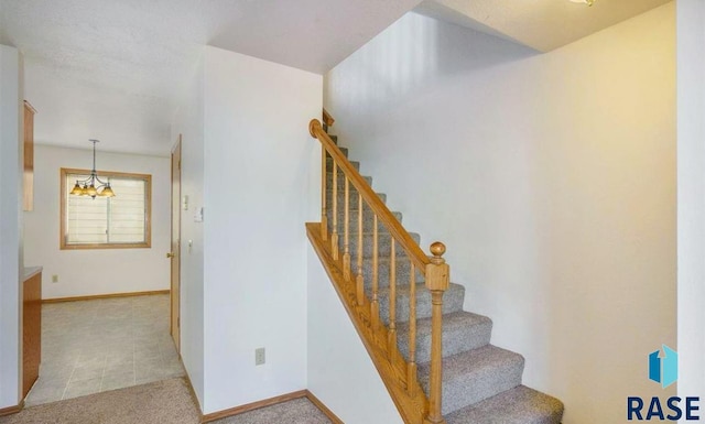 stairs featuring an inviting chandelier and carpet floors