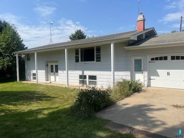 exterior space with a garage and a front lawn