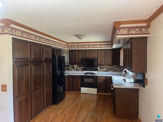 kitchen featuring a textured ceiling, hardwood / wood-style floors, sink, black appliances, and ornamental molding