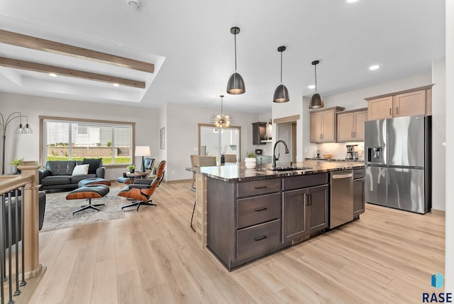 kitchen with light hardwood / wood-style flooring, stainless steel fridge with ice dispenser, a kitchen island with sink, and sink