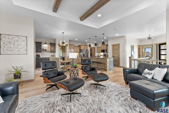 living room with an inviting chandelier, sink, beam ceiling, and light hardwood / wood-style floors