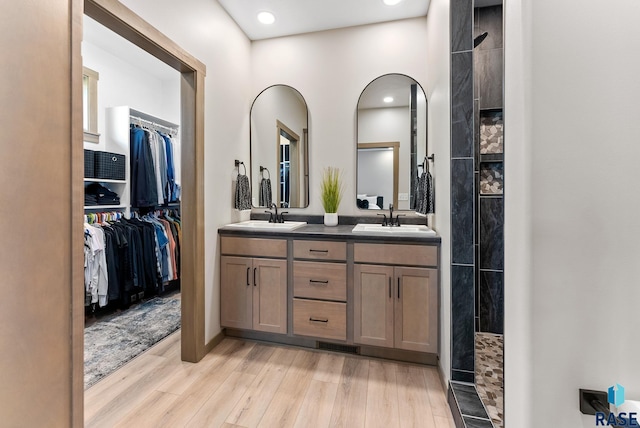 bathroom with vanity, hardwood / wood-style floors, and a shower