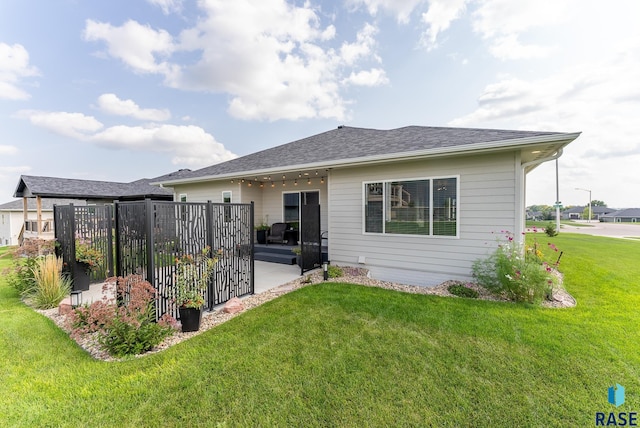 rear view of house featuring a lawn and a patio