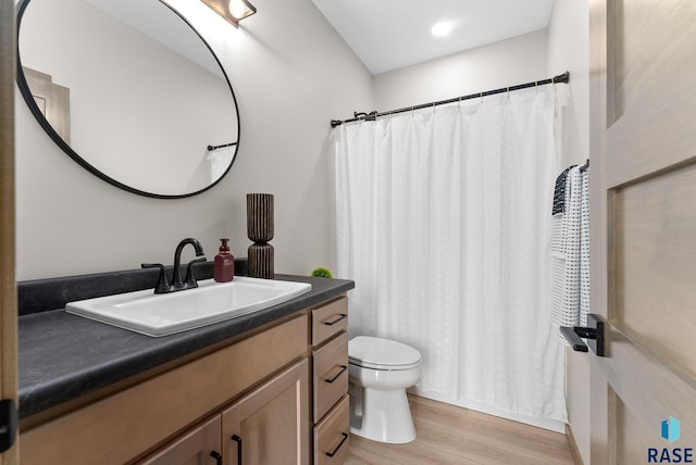 bathroom with vanity, toilet, hardwood / wood-style flooring, and curtained shower