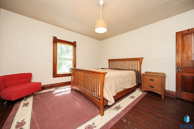 bedroom with baseboards and dark wood finished floors