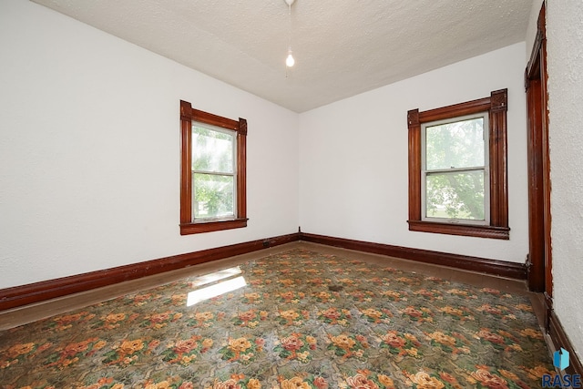 empty room featuring baseboards and plenty of natural light