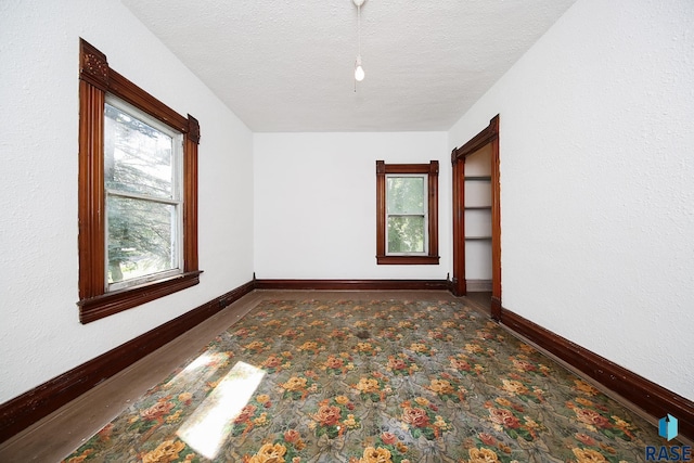 empty room featuring baseboards and a textured ceiling