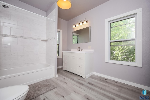 full bath featuring toilet, wood finished floors, vanity, baseboards, and shower / bathtub combination