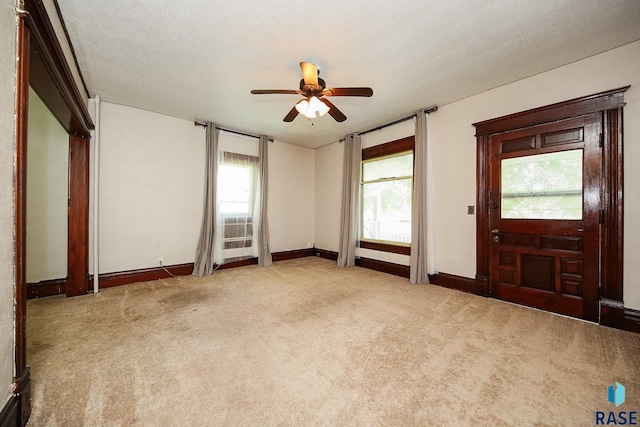 interior space featuring a ceiling fan, baseboards, carpet floors, and a textured ceiling