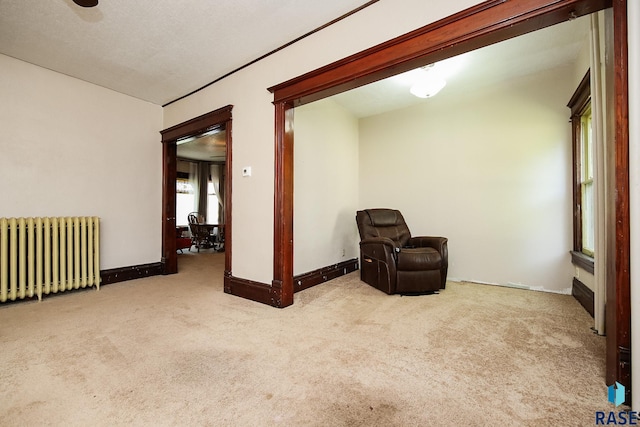 living area featuring radiator, baseboards, and carpet floors