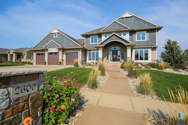 craftsman house featuring a garage and a front lawn