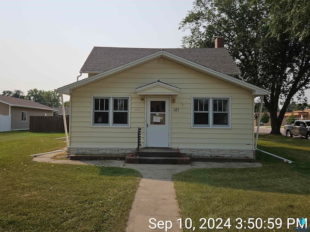 bungalow-style home with a front yard