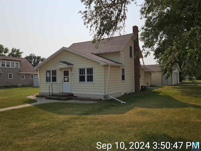 view of front of home with an outdoor structure and a front yard