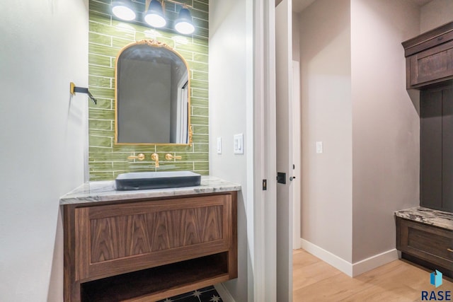 bathroom featuring vanity, hardwood / wood-style floors, and decorative backsplash