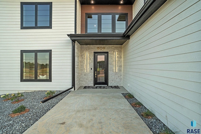 view of exterior entry with a patio