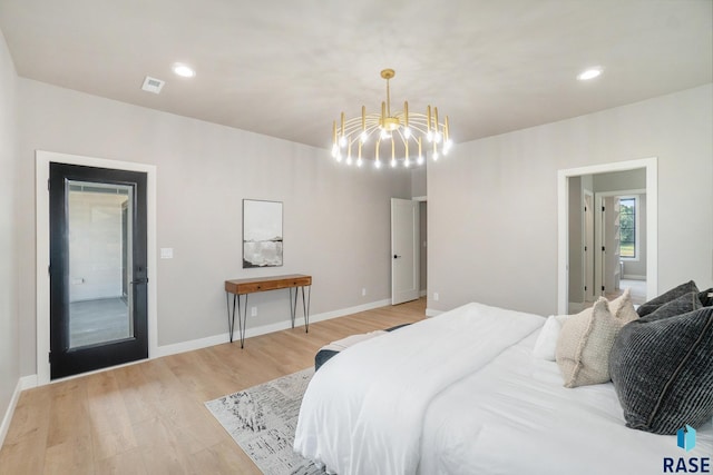 bedroom featuring light wood-type flooring and a notable chandelier