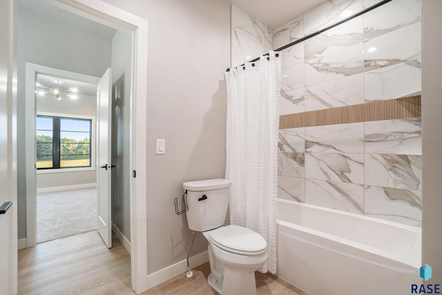 bathroom with toilet, hardwood / wood-style floors, and shower / bath combo