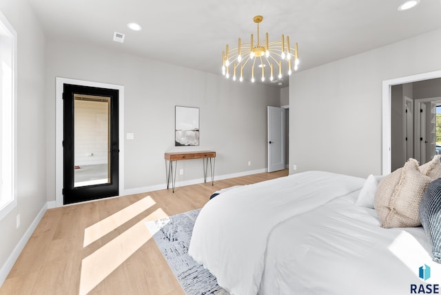 bedroom featuring an inviting chandelier and light hardwood / wood-style floors