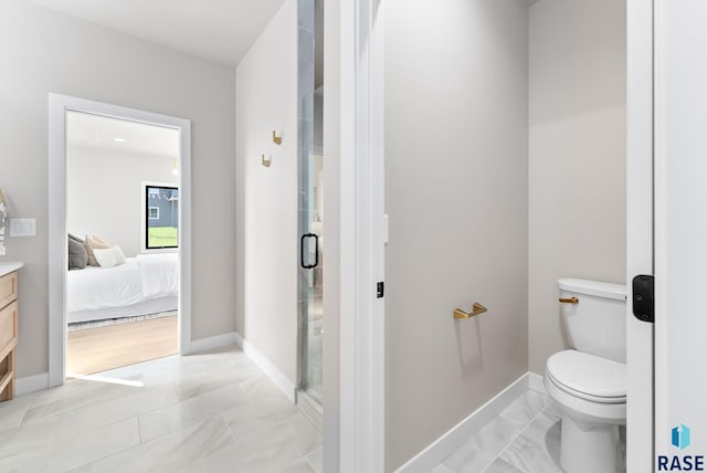 bathroom with a shower with shower door, vanity, and toilet