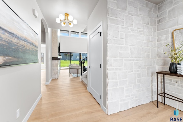 hallway with a chandelier and light hardwood / wood-style floors