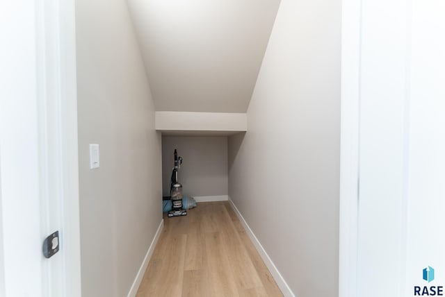 interior space featuring lofted ceiling and light hardwood / wood-style floors