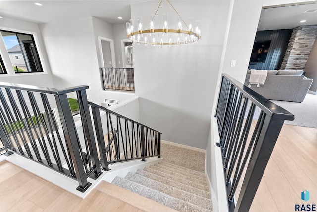 stairs with an inviting chandelier and hardwood / wood-style floors