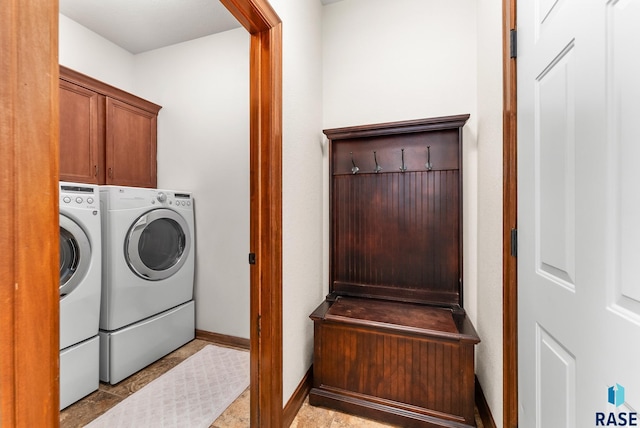 laundry room with washing machine and clothes dryer and cabinets