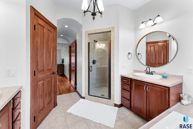 bathroom with vanity, an inviting chandelier, an enclosed shower, and wood-type flooring