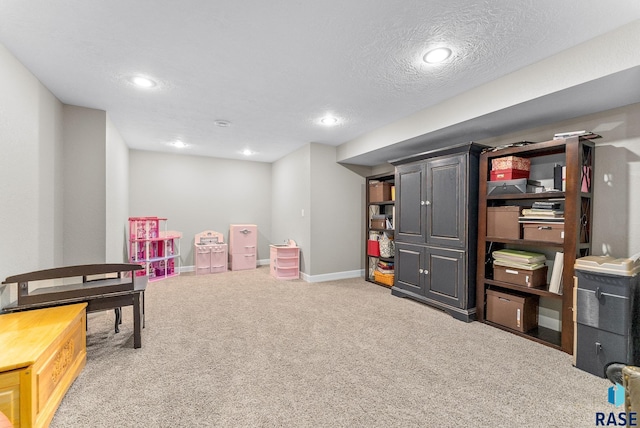 playroom featuring a textured ceiling and carpet floors