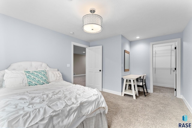 carpeted bedroom featuring a closet and a walk in closet