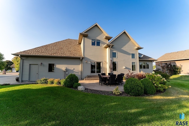 back of house featuring a lawn and a patio