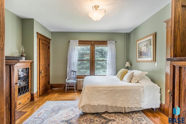 bedroom with light wood-type flooring and radiator