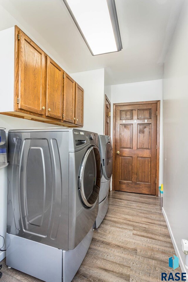 washroom featuring washer and clothes dryer and cabinets