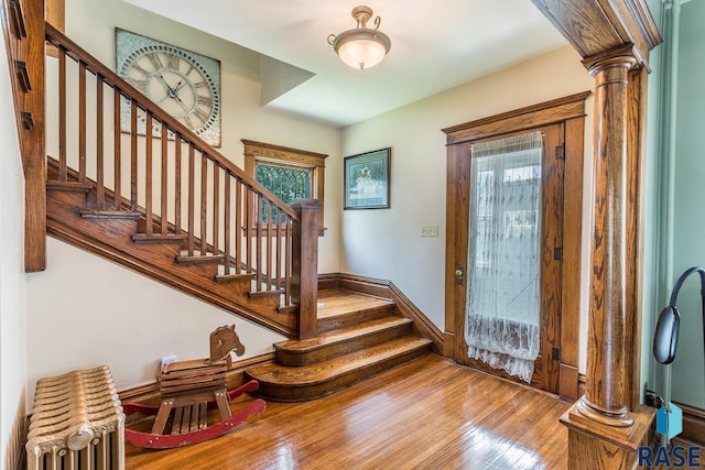 foyer featuring decorative columns and light hardwood / wood-style floors